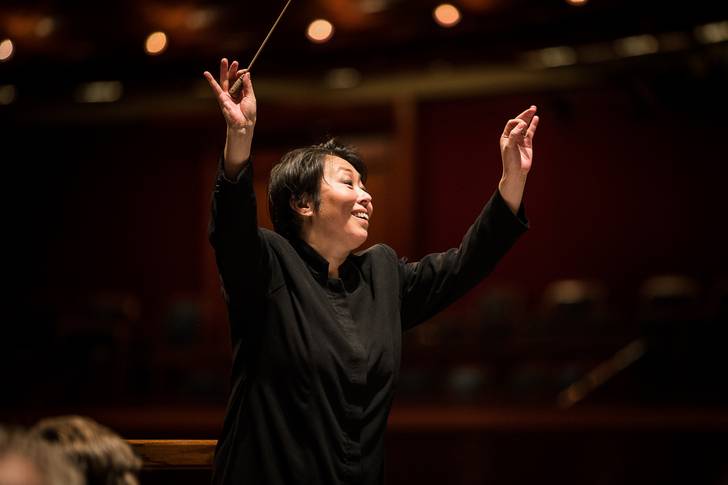 A woman conducting an orchestra.